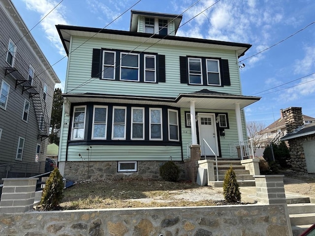 american foursquare style home with covered porch