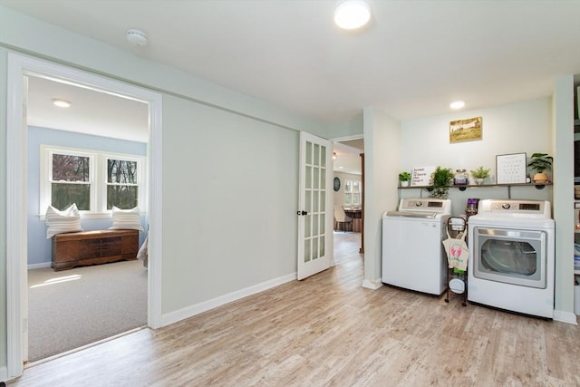 washroom featuring laundry area, baseboards, washing machine and dryer, and wood finished floors