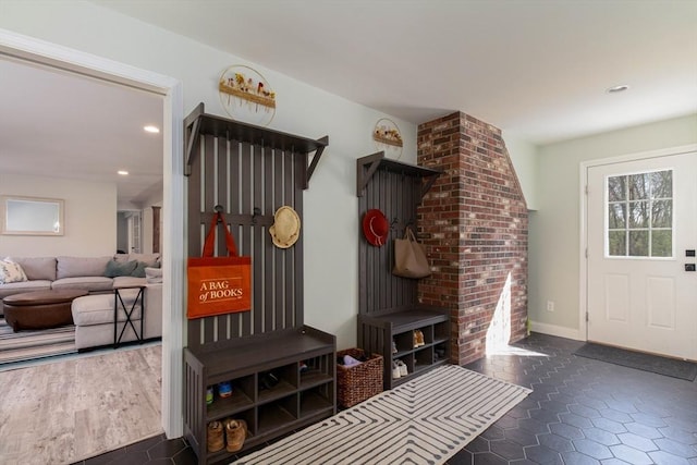 mudroom with dark tile patterned floors, baseboards, and recessed lighting