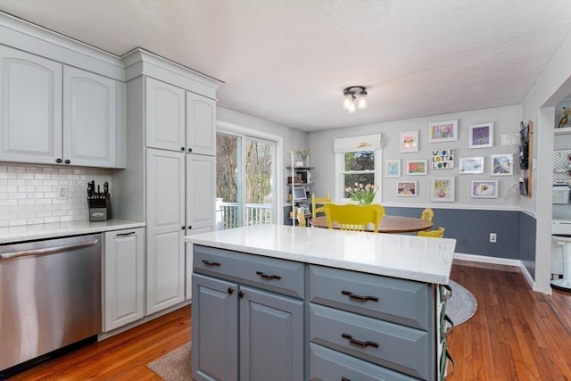 kitchen with light countertops, dark wood finished floors, dishwasher, and gray cabinetry