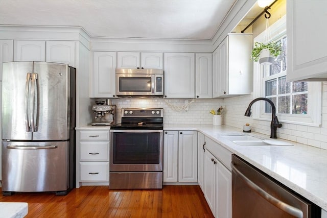 kitchen featuring a sink, white cabinetry, appliances with stainless steel finishes, and backsplash