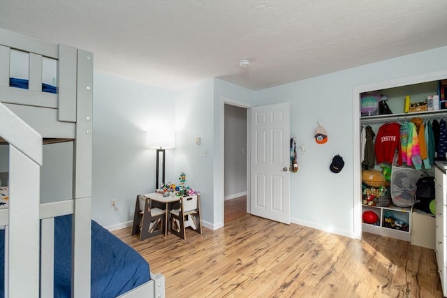 bedroom with baseboards, a closet, and wood finished floors