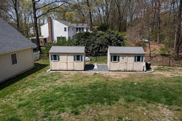 rear view of house featuring a storage shed, a yard, and a fenced backyard