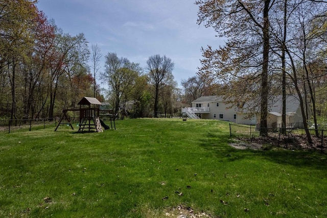 view of yard with stairway, fence, and a playground