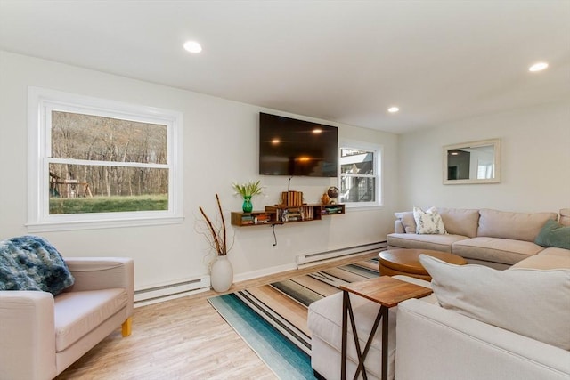 living area featuring a baseboard heating unit, recessed lighting, and wood finished floors