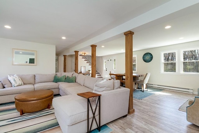 living area with light wood-style floors, stairs, recessed lighting, a baseboard radiator, and ornate columns