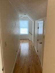 corridor featuring lofted ceiling and wood-type flooring