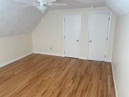 additional living space featuring hardwood / wood-style flooring, ceiling fan, and vaulted ceiling