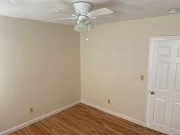 spare room featuring dark wood-type flooring and ceiling fan