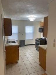 kitchen with light tile patterned flooring, appliances with stainless steel finishes, and sink