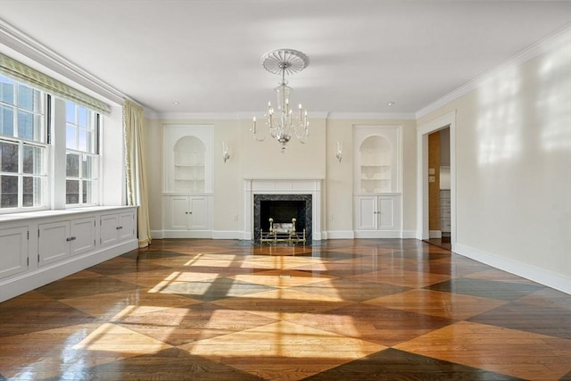 unfurnished living room featuring a premium fireplace, an inviting chandelier, crown molding, and built in features