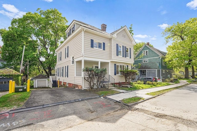 1 Melville St, Worcester, MA 01605 - view of front of house featuring a chimney, asphalt driveway, and an outdoor structure