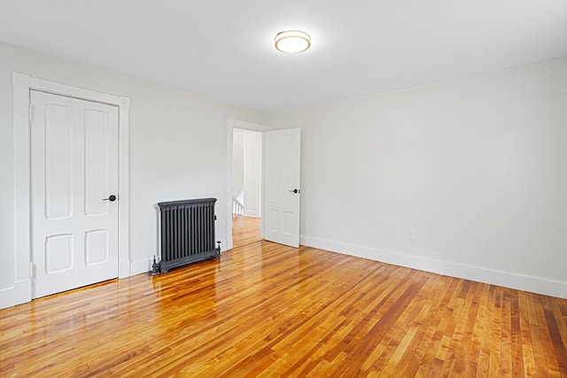 1 Melville St, Worcester, MA 01605 - unfurnished bedroom with light wood-type flooring, baseboards, and radiator