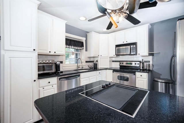 249 E Squantum St Unit 2, Quincy, MA 02171 - kitchen featuring stainless steel appliances, dark countertops, a ceiling fan, white cabinetry, and decorative backsplash