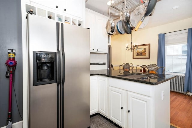 249 E Squantum St Unit 2, Quincy, MA 02171 - kitchen with stainless steel fridge with ice dispenser, dark countertops, white cabinetry, a chandelier, and a peninsula