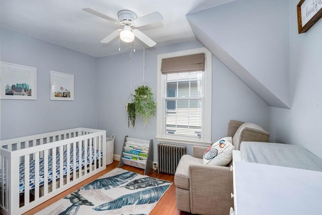 249 E Squantum St Unit 2, Quincy, MA 02171 - bedroom with radiator, wood finished floors, a nursery area, and a ceiling fan