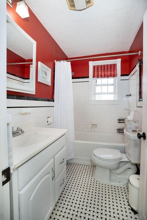 249 E Squantum St Unit 2, Quincy, MA 02171 - bathroom with tile walls, vanity, shower / bath combination with curtain, and wainscoting