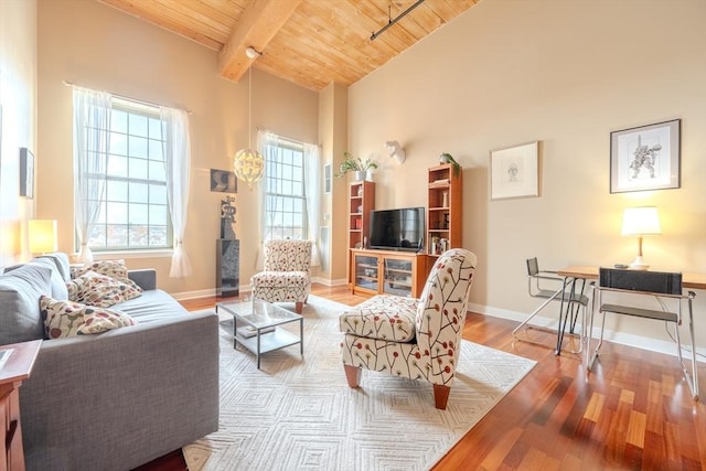 living room with vaulted ceiling with beams, wooden ceiling, and light hardwood / wood-style flooring