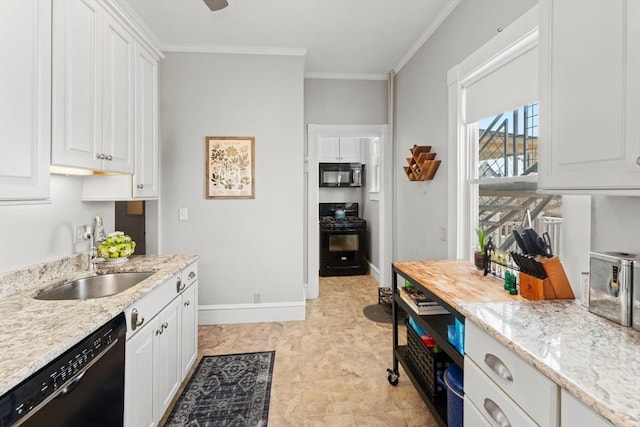 kitchen with black appliances, light stone counters, white cabinets, and a sink