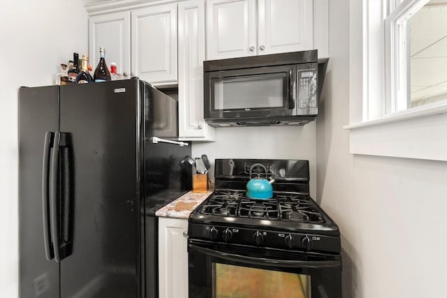 kitchen with black appliances, light countertops, and white cabinetry