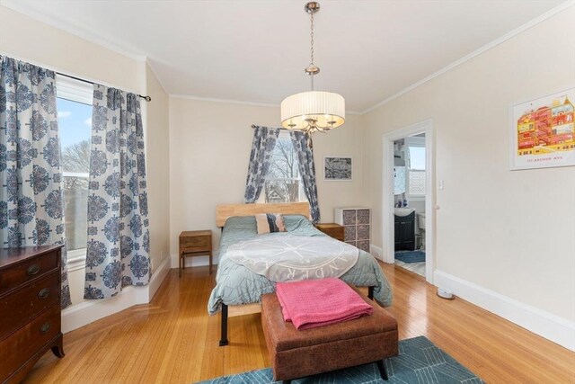 bedroom with baseboards, crown molding, and light wood finished floors