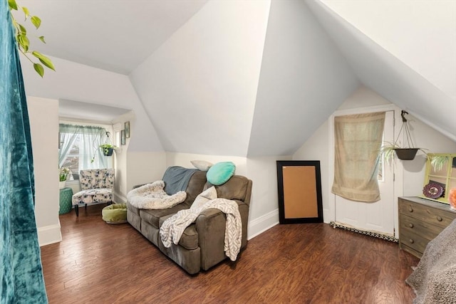 living area featuring vaulted ceiling, dark wood-type flooring, and baseboards