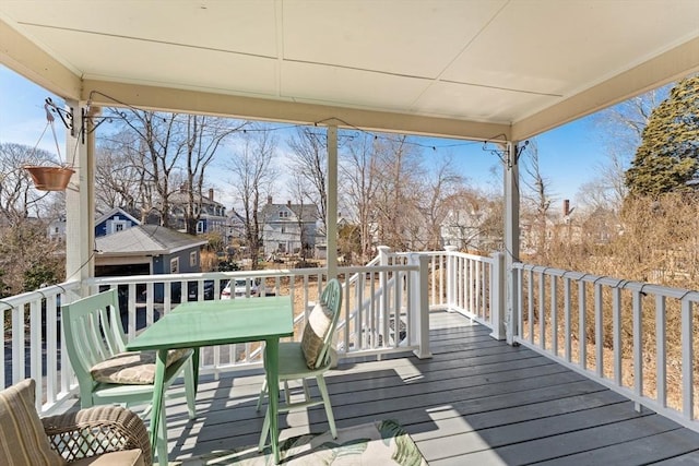 wooden terrace with outdoor dining space and a residential view