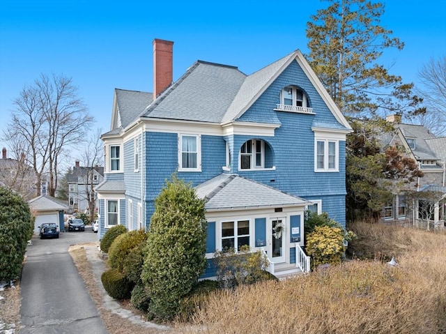 shingle-style home featuring a shingled roof and a chimney