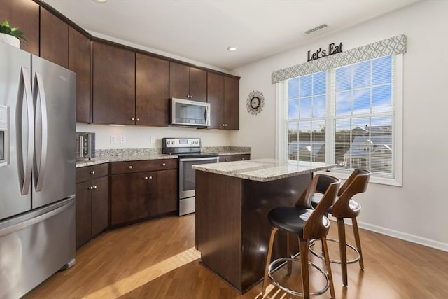 kitchen featuring dark brown cabinetry, appliances with stainless steel finishes, and a center island