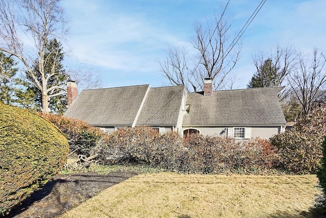 view of property exterior with a chimney and a shingled roof