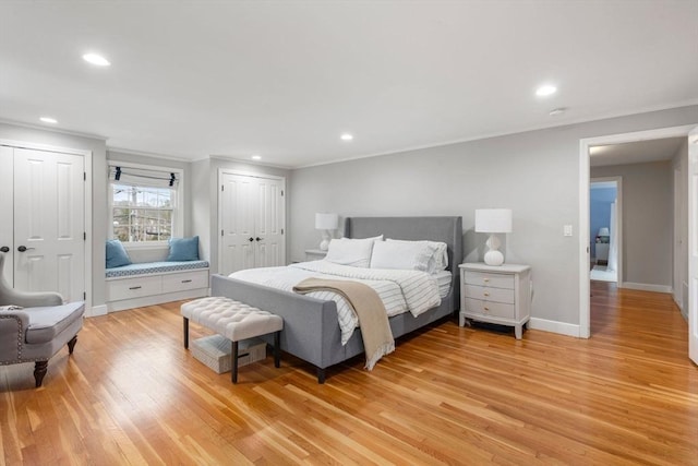 bedroom with crown molding, multiple closets, recessed lighting, light wood-style flooring, and baseboards