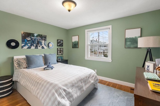 bedroom with baseboards and wood finished floors