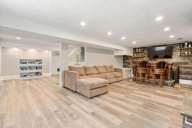 living room featuring light wood-style floors, recessed lighting, stairway, and a bar