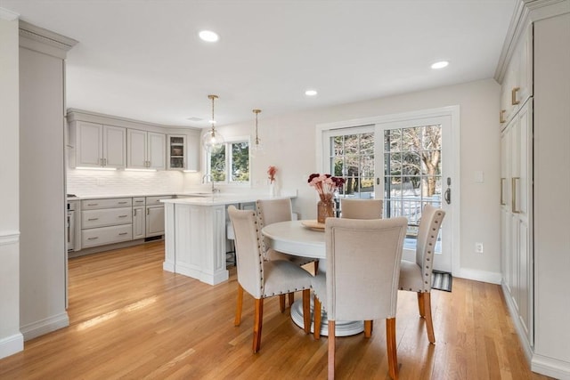 dining area with light wood finished floors, baseboards, and recessed lighting