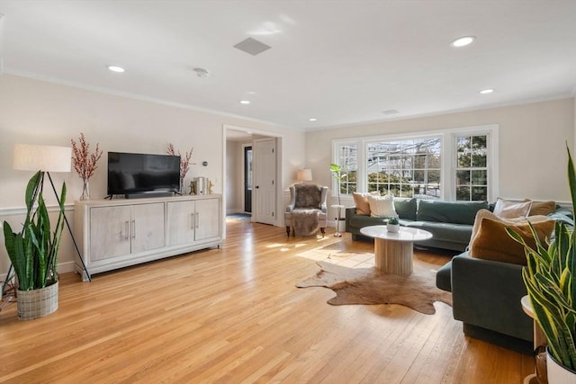 living room featuring recessed lighting, visible vents, crown molding, and light wood-style flooring