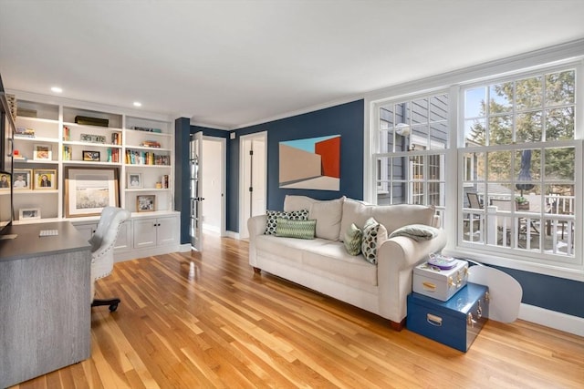 office area with crown molding, baseboards, and light wood-style floors