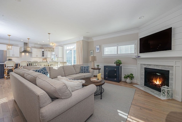 living room with ornamental molding and light hardwood / wood-style floors