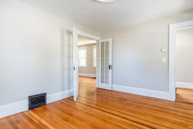 243 Bridge St, Northampton, MA 01060 - empty room with baseboards, light wood finished floors, and french doors