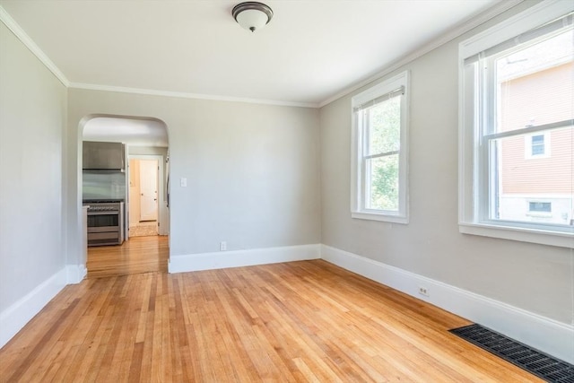 243 Bridge St, Northampton, MA 01060 - empty room featuring light wood-style flooring, arched walkways, baseboards, and crown molding