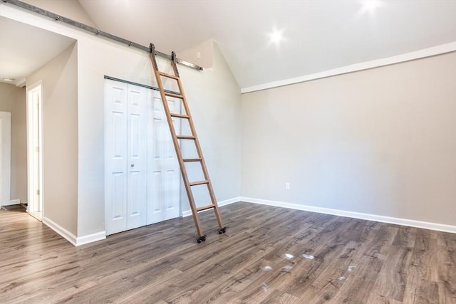 243 Bridge St, Northampton, MA 01060 - unfurnished room with a barn door, lofted ceiling, wood finished floors, and baseboards