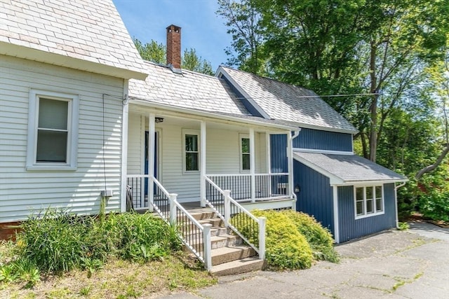 243 Bridge St, Northampton, MA 01060 - view of front of house with a chimney, a porch, and roof with shingles