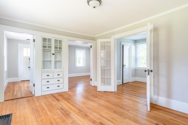 243 Bridge St, Northampton, MA 01060 - empty room featuring french doors, light wood-style floors, baseboards, healthy amount of natural light, and crown molding