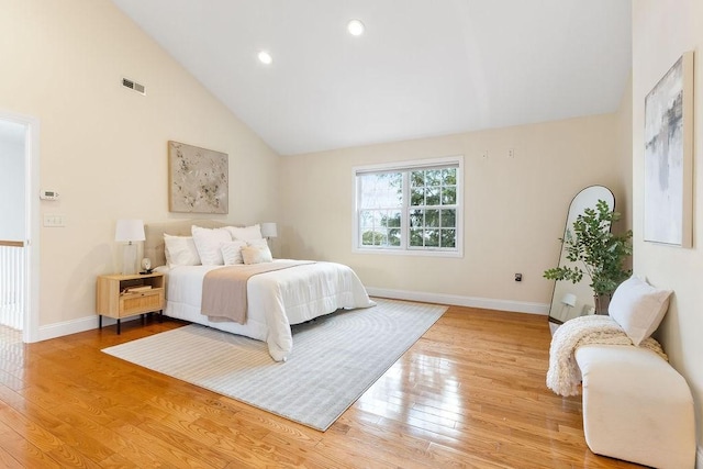 bedroom with light hardwood / wood-style flooring and high vaulted ceiling