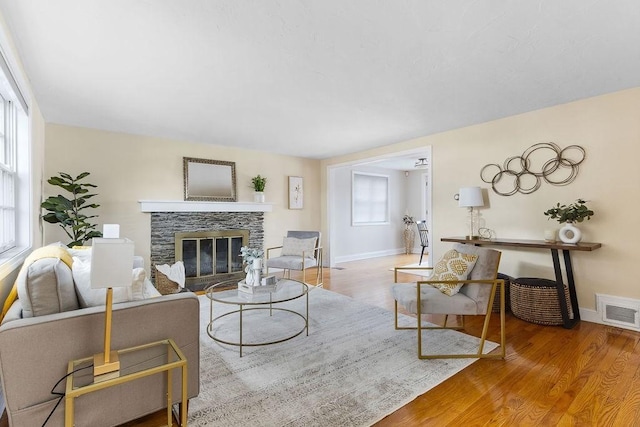 living room featuring hardwood / wood-style flooring and a stone fireplace