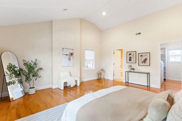 bedroom with high vaulted ceiling and hardwood / wood-style floors