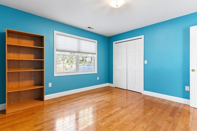 unfurnished bedroom with a closet and light wood-type flooring