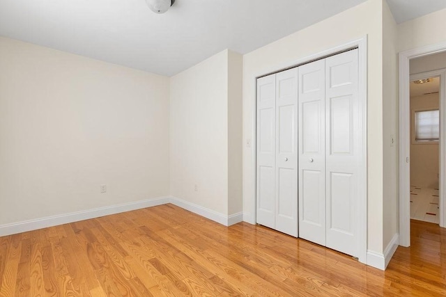 unfurnished bedroom featuring light hardwood / wood-style flooring and a closet