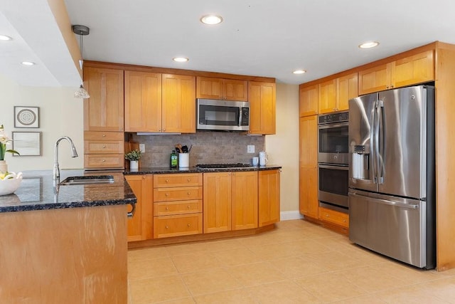 kitchen with sink, hanging light fixtures, backsplash, stainless steel appliances, and dark stone counters