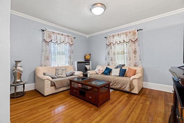 living area featuring ornamental molding, light wood-style flooring, and baseboards