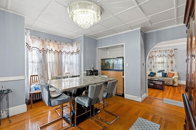 dining room with baseboards, a chandelier, healthy amount of natural light, and crown molding